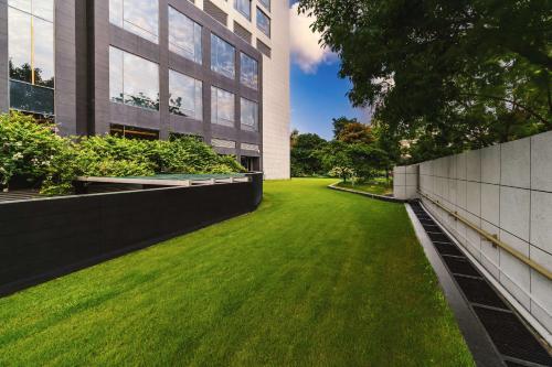 a green lawn in front of a building at Hyatt Regency Lucknow Gomti Nagar in Lucknow
