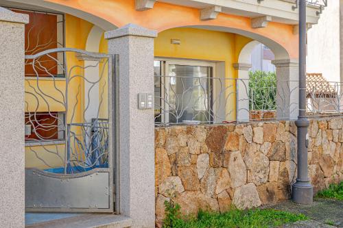 a building with a gate and a stone wall at Colombo Apartament in Golfo Aranci
