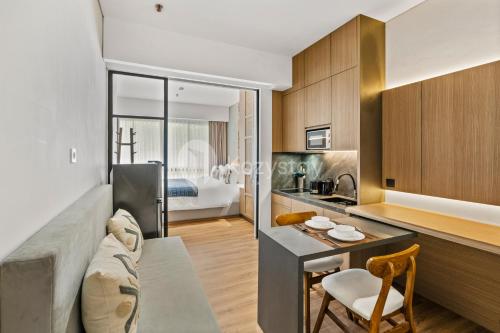 Una cocina y una sala de estar con un sofá y una mesa. en Calira by Kozystay - Nusa Dua, en Nusa Dua