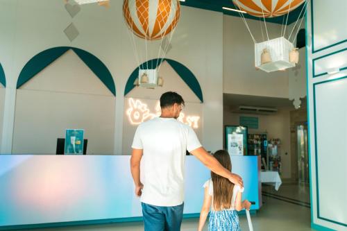 a man and a little girl playing a video game at Hotel Magic Fantasy in Oropesa del Mar