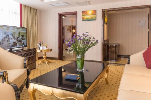 a living room with a vase of flowers on a table at Golden Tulip Addis Ababa in Addis Ababa