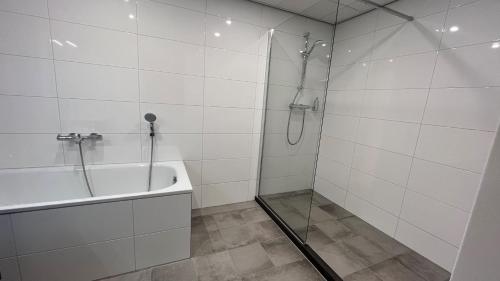 a bathroom with a shower and a tub and a sink at Fletcher Hotel Jan van Scorel in Schoorl