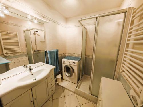 une salle de bain avec un lavabo et une machine à laver dans l'établissement LE VALPA Face Mer Garage, à Les Sables-dʼOlonne