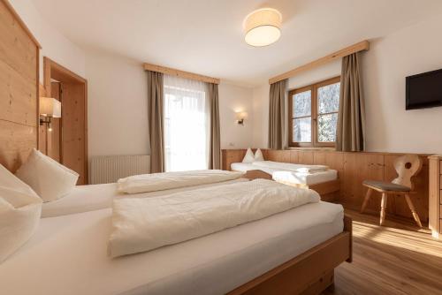 pokój hotelowy z dwoma łóżkami i telewizorem w obiekcie Landhaus Pfurtscheller w Neustift im Stubaital