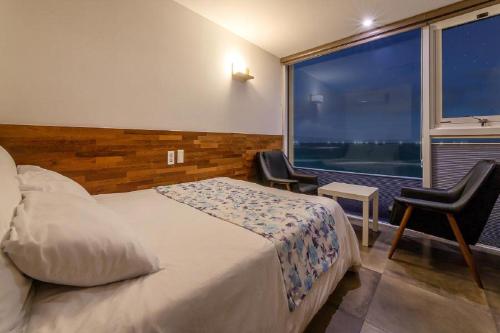 a hotel room with a bed and a large window at Jeju Dalbeach Pension in Jeju