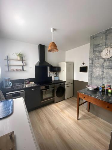 une cuisine avec une cuisinière et un réfrigérateur dans l'établissement Katel chez elle - Maison 5 pers, à Saint-Christophe-du-Bois