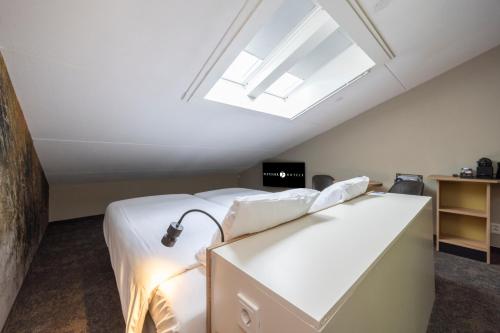a bedroom with a bed and a skylight at Fletcher Hotel Jan van Scorel in Schoorl