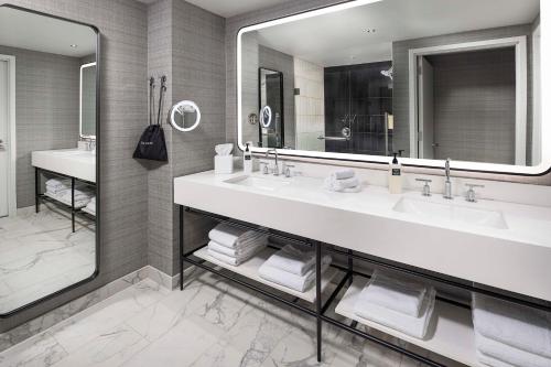 a bathroom with two sinks and a large mirror at Signia By Hilton Atlanta Georgia World Congress Center in Atlanta