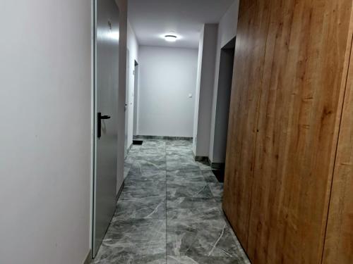 a hallway with a door and a tile floor at CIty Host Impresja P4 in Pabianice