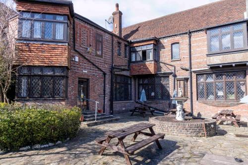 a building with a picnic table in front of it at Roebuck by Greene King Inns in Forest Row