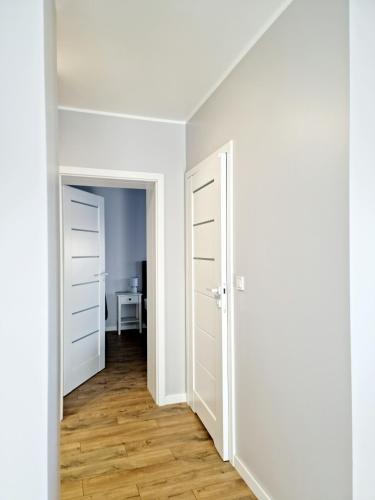 an empty room with two doors and a table at CIty Host Impresja P4 in Pabianice