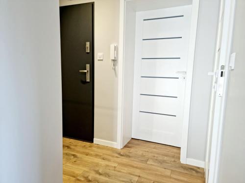 an open door in a room with a wooden floor at CIty Host Impresja P4 in Pabianice