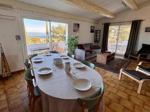 - une table dans le salon avec une grande fenêtre dans l'établissement Villa Les Genêts, à La Ciotat