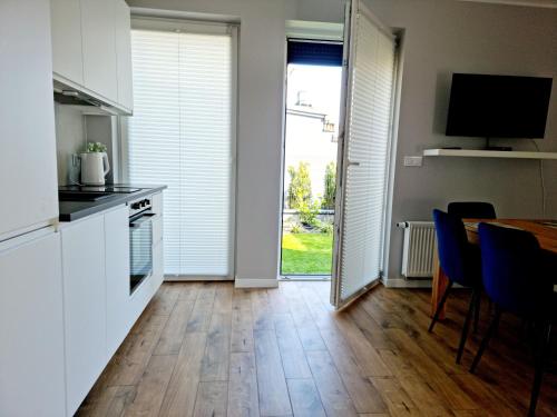 a kitchen and dining room with a table and a television at CIty Host Impresja P4 in Pabianice