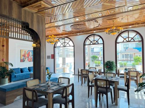 a restaurant with tables and chairs and a blue couch at ORCHID Hotel in Da Lat
