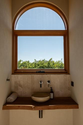 a bathroom with a sink under a window at Stone - Rare Earth Retreats in McLaren Vale