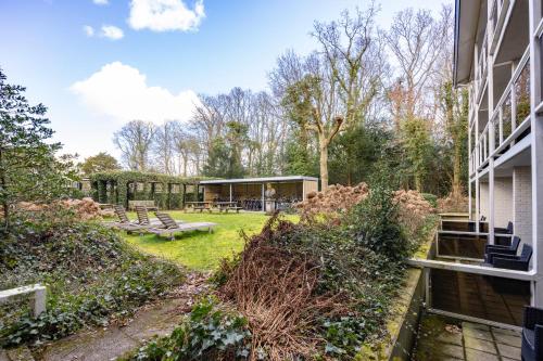 a view of a yard with a house at Fletcher Hotel Jan van Scorel in Schoorl