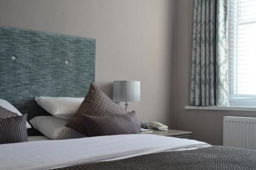 a bedroom with a bed and a table with a lamp at The Osborne Hotel in Torquay
