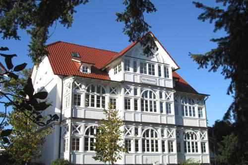 a large white building with a red roof at Villa Malepartus by Rujana in Binz