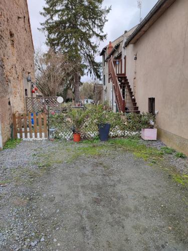 a yard with some plants and a building at Le nid du Berry in Célon