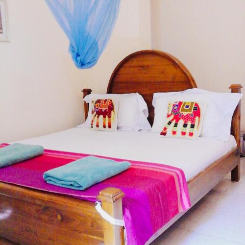 a bedroom with a bed with a wooden headboard at Suwani Pinnawala Homestay in Pinnawala