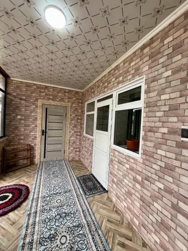 a room with a brick wall and a white door at October Guesthouse in Jalal-Abad