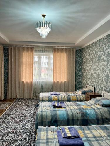 a bedroom with two beds and a chandelier at October Guesthouse in Jalal-Abad