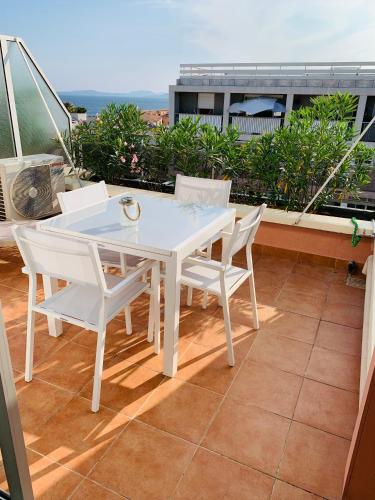 a white table and chairs on a balcony at Appartement Saint-Raphaël in Saint-Raphaël