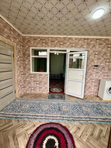 a room with a door and a rug on the floor at October Guesthouse in Jalal-Abad