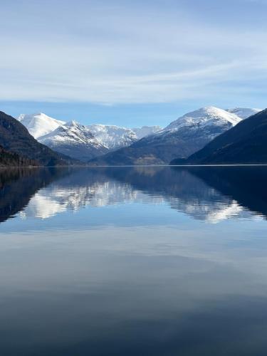 a view of a lake with snow covered mountains at Faleide View in Stryn