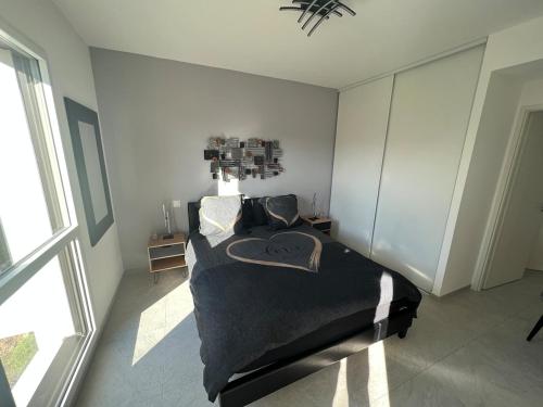 une chambre avec un lit dans une pièce avec une fenêtre dans l'établissement T2 neuf tout équipé ! Climatisation, wifi, parking privatif, à Saint-Mandrier-sur-Mer