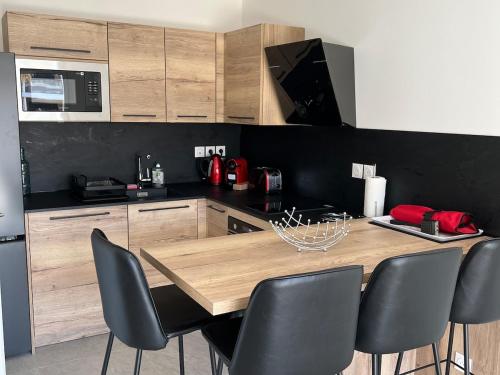 une cuisine avec une table en bois et quelques chaises dans l'établissement T2 neuf tout équipé ! Climatisation, wifi, parking privatif, à Saint-Mandrier-sur-Mer