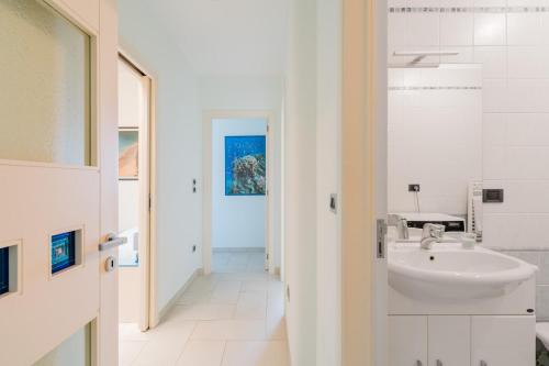 een witte badkamer met een wastafel en een hal bij Dimora di Artemide in Otranto
