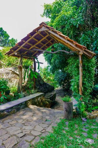 a wooden pergola with a bench in a garden at New Villa - Nugaliyadda in Kandy