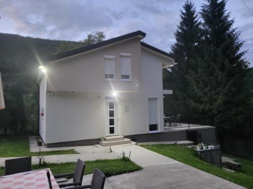 a white house with a porch and trees at Weekend house Mila in Bijelo Polje