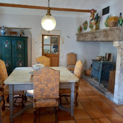 une salle à manger avec une table et des chaises et une cheminée dans l'établissement La Manhanéra, à Bouquet