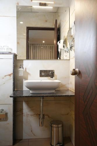 a bathroom with a sink and a mirror at Mysore Elite in Mysore