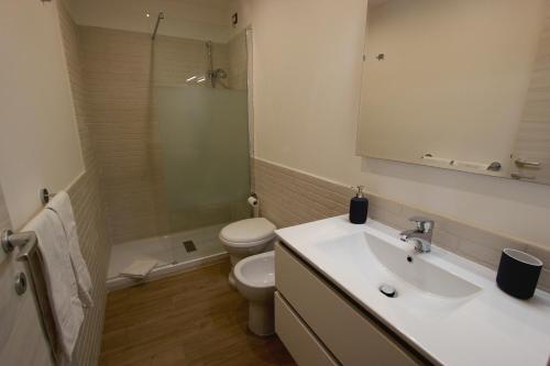 a bathroom with a sink and a toilet and a mirror at Pianeta Roma 127 in Rome