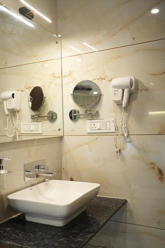 a bathroom with a sink and a mirror at Mysore Elite in Mysore