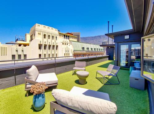 a balcony with chairs and furniture on a roof at BlackBrick Cape Town Foreshore in Cape Town