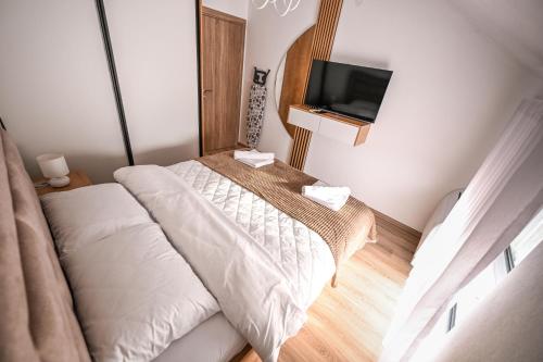 a bedroom with two beds and a flat screen tv at Apartmani EMA SL in Vranje