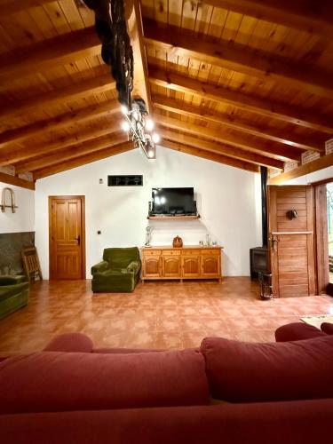 a living room with a couch and a flat screen tv at Chalet con zona de asador en Quijas in Valles