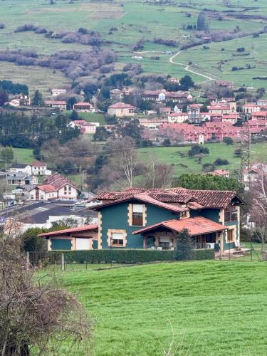 a house on a hill with a green field at Chalet con zona de asador en Quijas in Valles