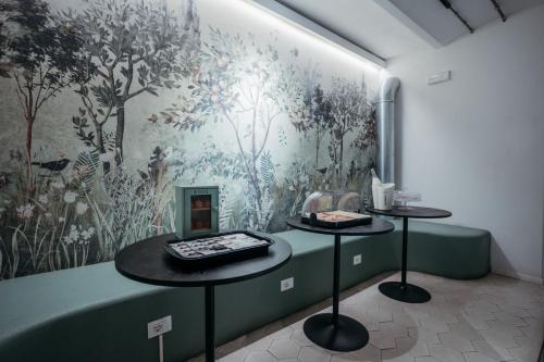 a room with two tables in front of a wall at Casali Hostel in Trieste