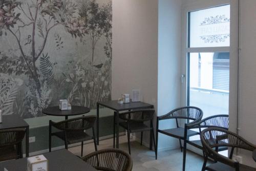 a dining room with tables and chairs and a wall mural at Casali Hostel in Trieste
