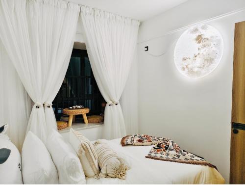 a bedroom with white curtains and a bed with a window at Tung Blossom House in Kunming