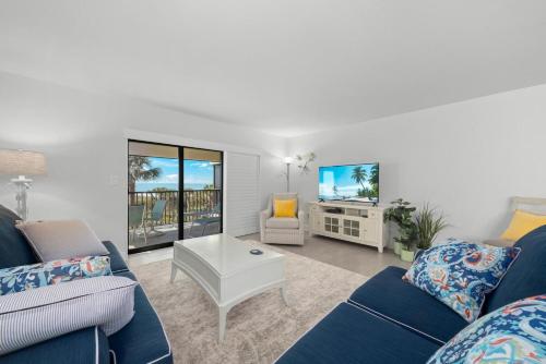 Una sala de estar con un sofá azul y un televisor. en Sanddollar #A201, en Ybel