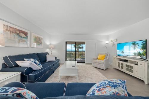 Una sala de estar con un sofá azul y un televisor de pantalla plana. en Sanddollar #A201, en Ybel