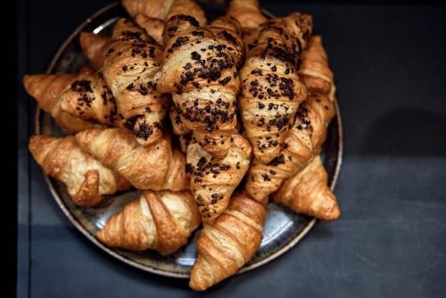 a plate of bread and croissants on a table at Hotel Roter Hahn in Regensburg
