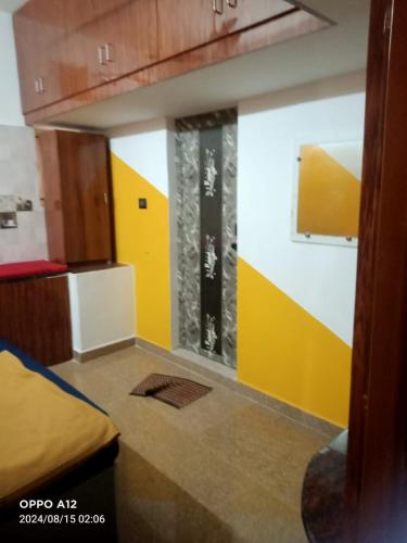 a room with a yellow and white wall at ASSHAPPYSTAYINN HOTEL in Tiruchchirāppalli